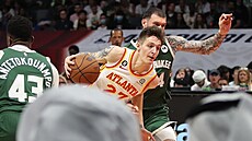 Vít Krej�í z Atlanty táhne útok v zápase s Milwaukee, brání ho Sandro...