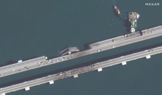 Krymský most po útoku ukrajinských dron. Bariéra z plavidel má základy mostu do budoucna ochránit.