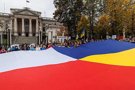 Lidé ped ruským velvyslanectvím ve Varav drí spolenou vlajku Ukrajiny a...