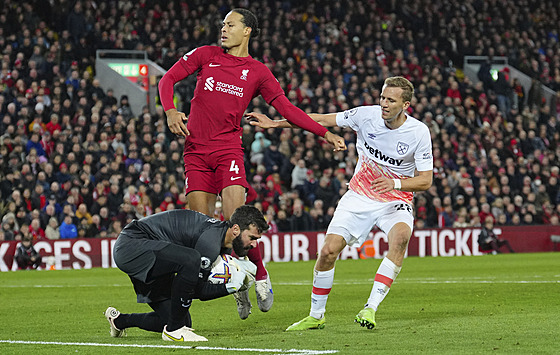 Liverpoolský branká Alisson polapil mí, napadá ho Tomá Souek (v bílém) z...