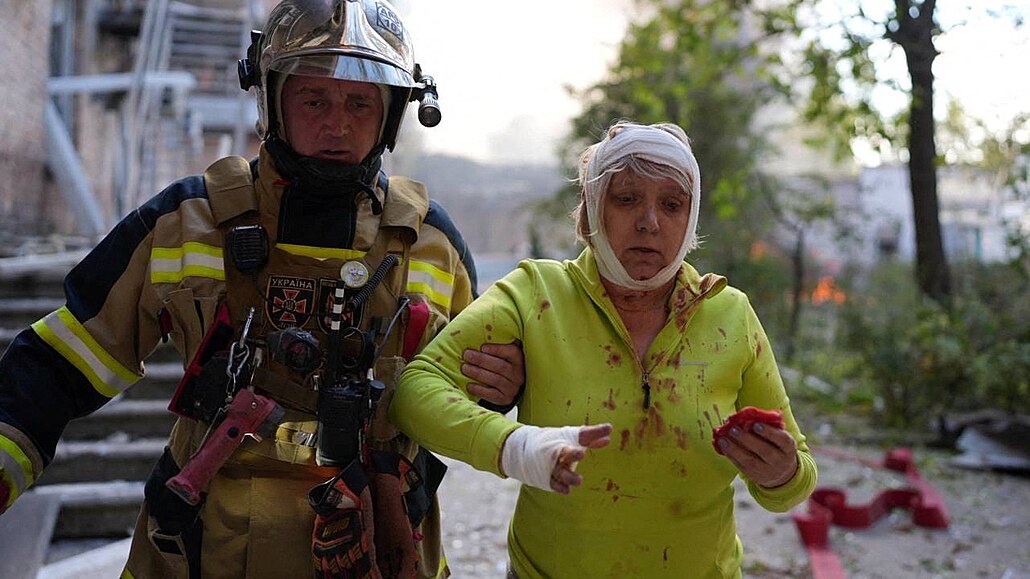 Ukrajinský záchraná odvádí zrannou enu z místa v Kyjev, kde se nachází...