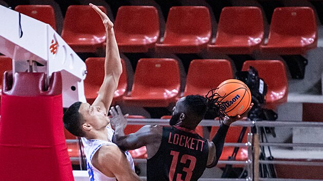 Eric Lockett (vpravo) z Nymburka zakonuje na ko Igokey kolem Nikoly...