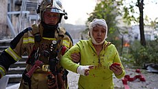 Ukrajinský záchraná odvádí zrannou enu z místa v Kyjev, kde se nachází...