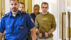 Eskorta odvádí Davida V. obžalovaného z vražd pražských taxikářů k soudu.