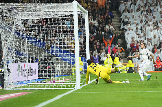 Luka Modri z Realu Madrid (vpravo) stílí gól do sít brankáe Bona ze Sevilly.