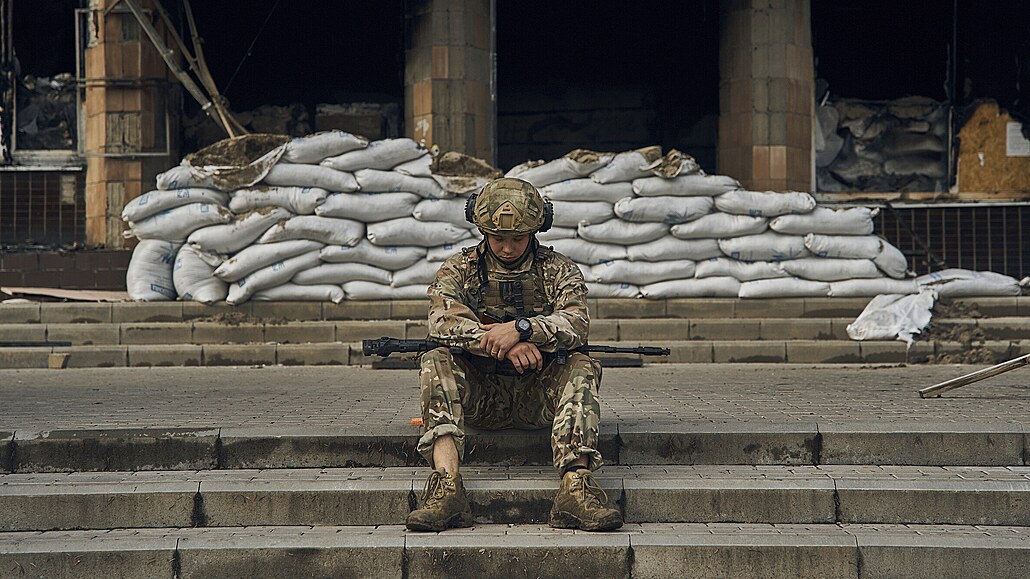 Ukrajinský voják odpoívá na schodech radnice v Izjumu v Charkovské oblasti....