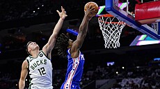 Tyrese Maxey (vpravo) z Philadelphie zakonuje na ko Milwaukee, zabránit se mu...