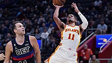 Trae Young z Atlanty zakon�uje na ko� Detroitu. Sleduje ho Bojan Bogdanovi�.