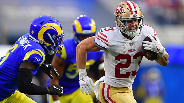 Christian McCaffrey (23) ze San Francisco 49ers unik obran Los Angeles Rams, chyt ho Derion Kendrick.