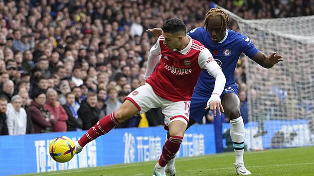 Gabriel Martinelli z Arsenalu si kryje balon ped Trevohem Chalobahem, fotbalistou Chelsea.