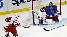 Filip Hronek z Detroitu stílí na brankáe. Jaroslava Haláka z New York Rangers.