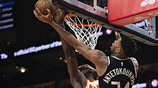 Janis Adetokunbo (vpravo) z Milwaukee zakon�uje p�es bránícího Clinta Capelu z...