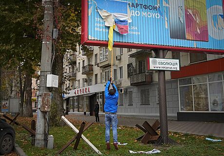 Místní obyvatel odstrauje ruskou vlajku z billboardu v centru Chersonu. (13....