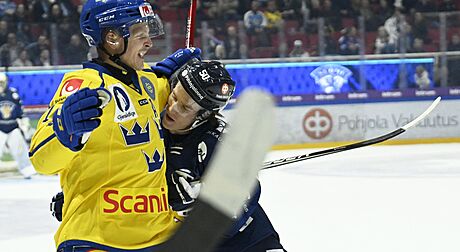 védský hokejista Max Friberg (vlevo) v souboji s Juusem Riikolou z Finska.