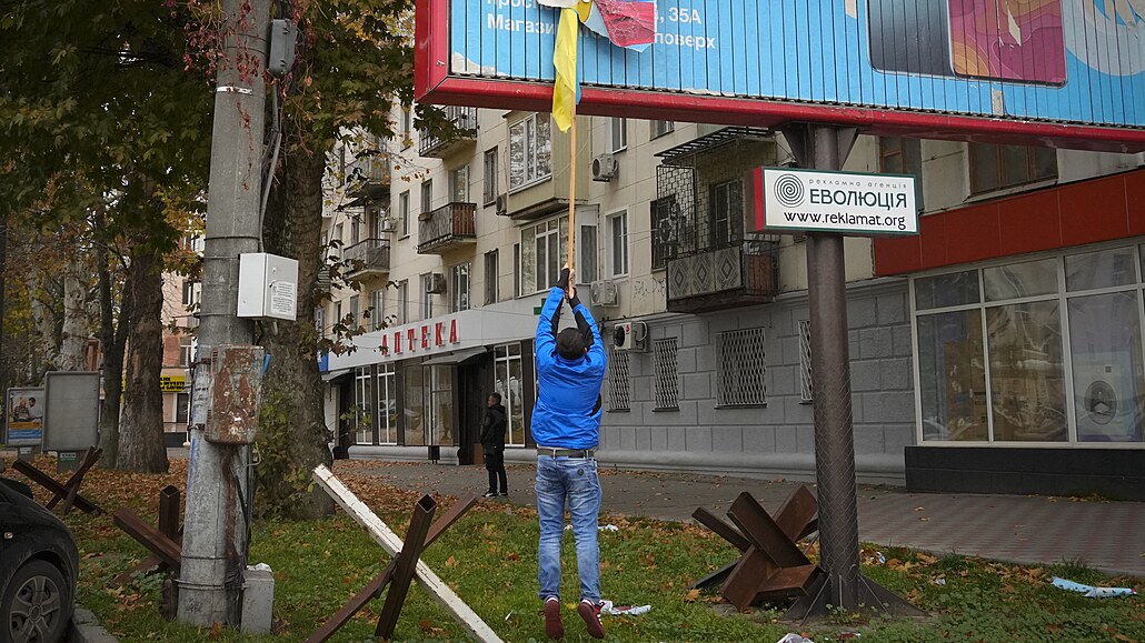 Místní obyvatel odstrauje ruskou vlajku z billboardu v centru Chersonu. (13....