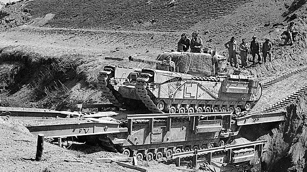 Churchill ARK není klasický mostní tank pokládající mostovku, ale sám se stává mostem. Zde vidíme dva takové stroje na sobě, přemosťující hlubokou překážku, přičemž po tom horním přejíždí tank Churchill standardního provedení.