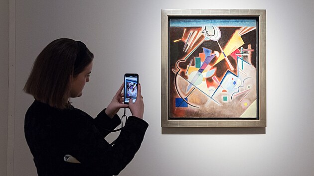Dražba v New Yorku nazvaná Visionary (Vizionář). Žena si fotí obraz „Tiefes Braun“, který namaloval Vasilij Kandinskij. (14. října 2022)