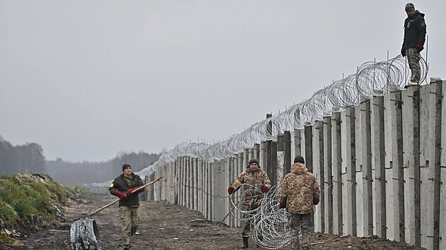 Ukrajintí vojáci budují ze s ostnatými dráty na hranici s Bloruskem. (11....