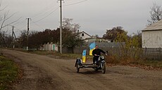 Uitel Jurij Nevoluk jede na motocyklu s národními vlajkami ve vesnici...