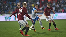 Jan Juroška z Ostravy se snaží zpracovat míč dřív, než se to podaří Jaroslavu...