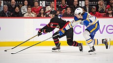 Alex DeBrincat (12) z Ottawa Senators ujídí obran Buffalo Sabres, nahání ho...