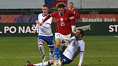 Reprezentaní fotbalista Alex Král se prodírá skrz obranu Faerských ostrov.