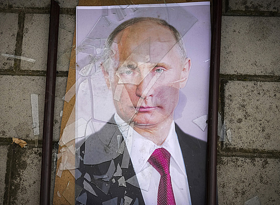 Rozbitý portrét ruského prezidenta Vladimira Putina leící na ulici v Chersonu...
