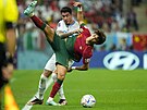 Portugalský útoník Joao Felix v akrobatické pozici v souboji s Jose Gimenezem...