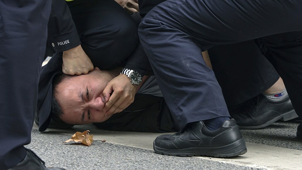 Policisté zatýkají demonstranta během protestu na ulici v Šanghaji. (27....