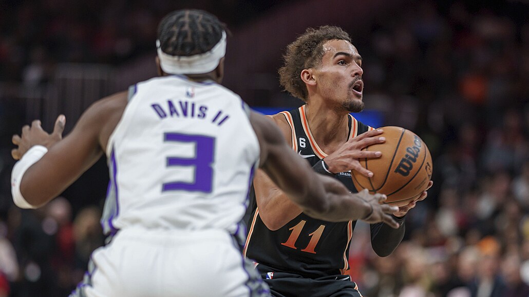 Hv�zda Atlanty Trae Young (11) se pokou�í o p�ihrávku p�es bránícího Terence...
