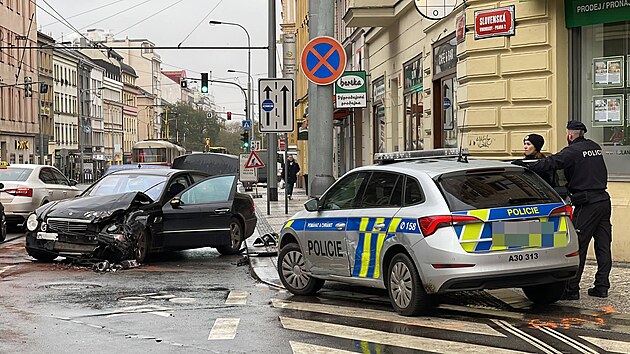 Muž naboural tramvaj, policejní vůz a auto stojící za ním. (29. listopadu 2022)