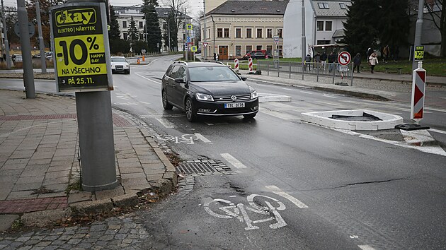Cyklista v cyklopruhu musí u DKO počítat se záludnostmi: jsou zde propadající se kanály, díry v asfaltu, vydutý povrch či čnějící žulové kostky na autobusové zastávce.