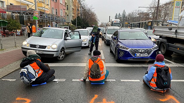 Aktivist z Letzte Generationse pilepili k silnici, aby blokovali dopravu bhem rann piky v Berln. (21. listopadu 2022)