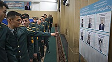 Kazaský vojáci ped ivotopisy prezidentských kandidát ve volební místnosti....