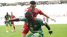 Kamerunský obránce Collins Fai si kryje míč před Rubenem Vargasem ze Švýcarska.