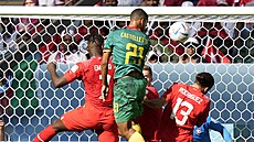 Kamerunský stoper Jean-Charles Castelletto se snaží usměrnit míč hlavou na...