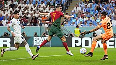 Portugalský útoník Cristiano Ronaldo se snail hlavikovat, uruguayský branká...