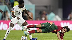 Portugalský fotbalista Joao Felix padá po stetu s Danielem Amarteyem z Ghany.
