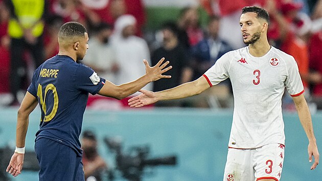 Francouz Kylian Mbapp a Tunisan Muntasar Talb si podvaj ruce po zpase.