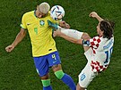 Chorvatský kapitán Luka Modri atakuje hlavikujícího Brazilce Richarlisona.