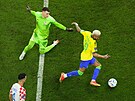 Brazilec Neymar obchází chorvatského gólmana Dominika Livakovie a následn...
