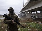 Ukrajinský voják hlídkuje oblast poblí Antonovského mostu, který zniily ruské...