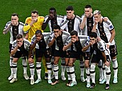 Němečtí fotbalisté si zakrývá ústa, když pózují pro týmový obrázek před...