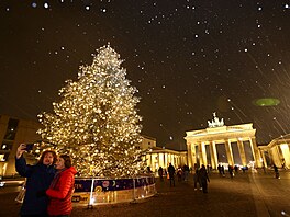 Ped Braniborskou bránou v Berlín svítí vánoní strom. Msta patin záí po...