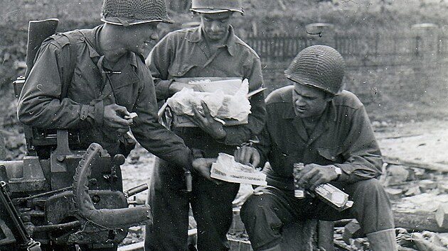 Amerit vojci rozbaluj vnon balek z domova na front ke konci roku 1944.