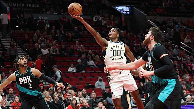 Bennedict Mathurin (00) z Indiana Pacers zakonuje na ko Portland Trail Blazers, sleduj ho Trendon Watford (vlevo) a Jusuf Nurki.