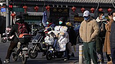 Lidé přecházejí ulici v Pekingu. (7. prosince 2022)