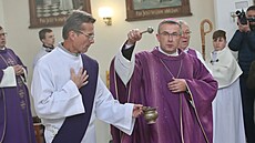 Biskup Martin David kropící zneuctný kostel svcenou vodou.(4. prosince 2022)