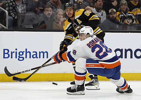 David Pastrák (nahoe) z Boston Bruins pihrává v zápase s New York Islanders...