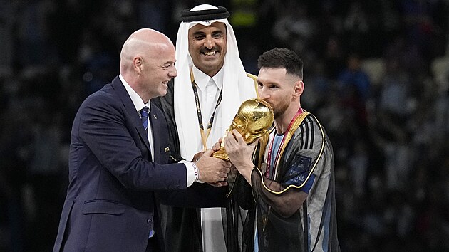 Argentinsk kapitn Lionel Messi pebr trofej pro vtze mistrovstv svta od prezidenta FIFA Gianniho Infantina a katarskho emra Tamma bin Hamada l Thnho. (18. prosince 2022)